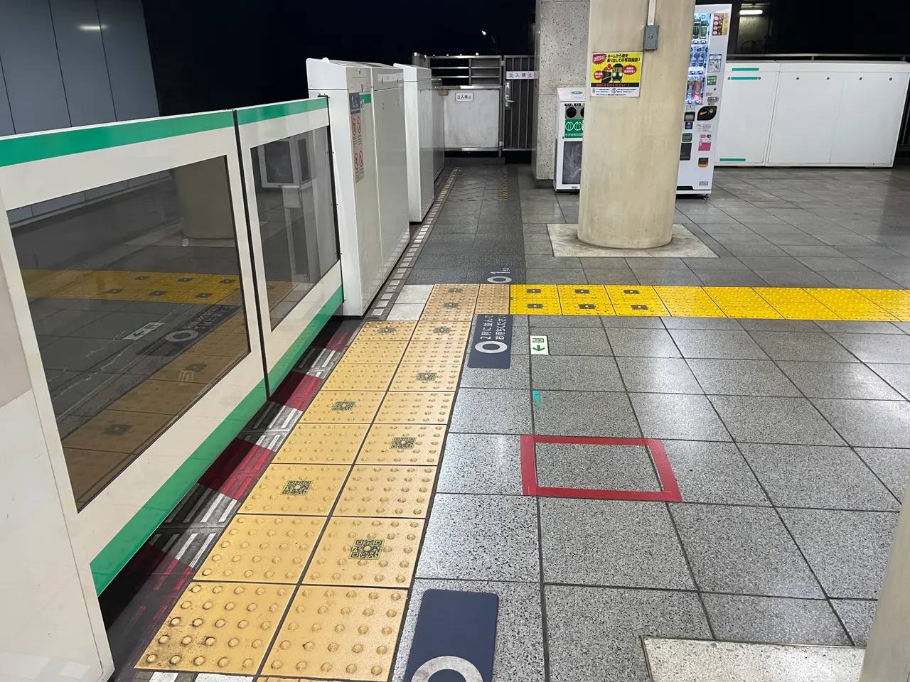 Gelbes taktiles Blindenleitsystem entlang der Bahnsteigkante mit Bahnsteigtüren an einer japanischen Bahnstation.