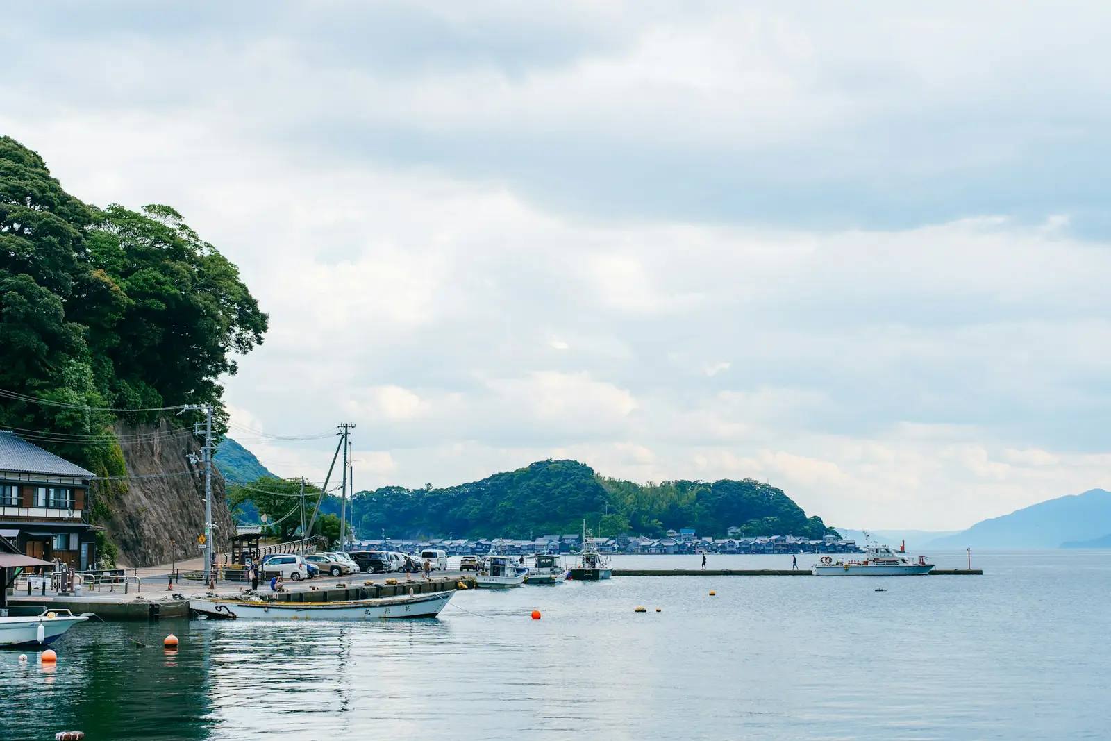 Stille Bucht an der japanischen Küste mit kleinen Fischerbooten und grünen Hügeln