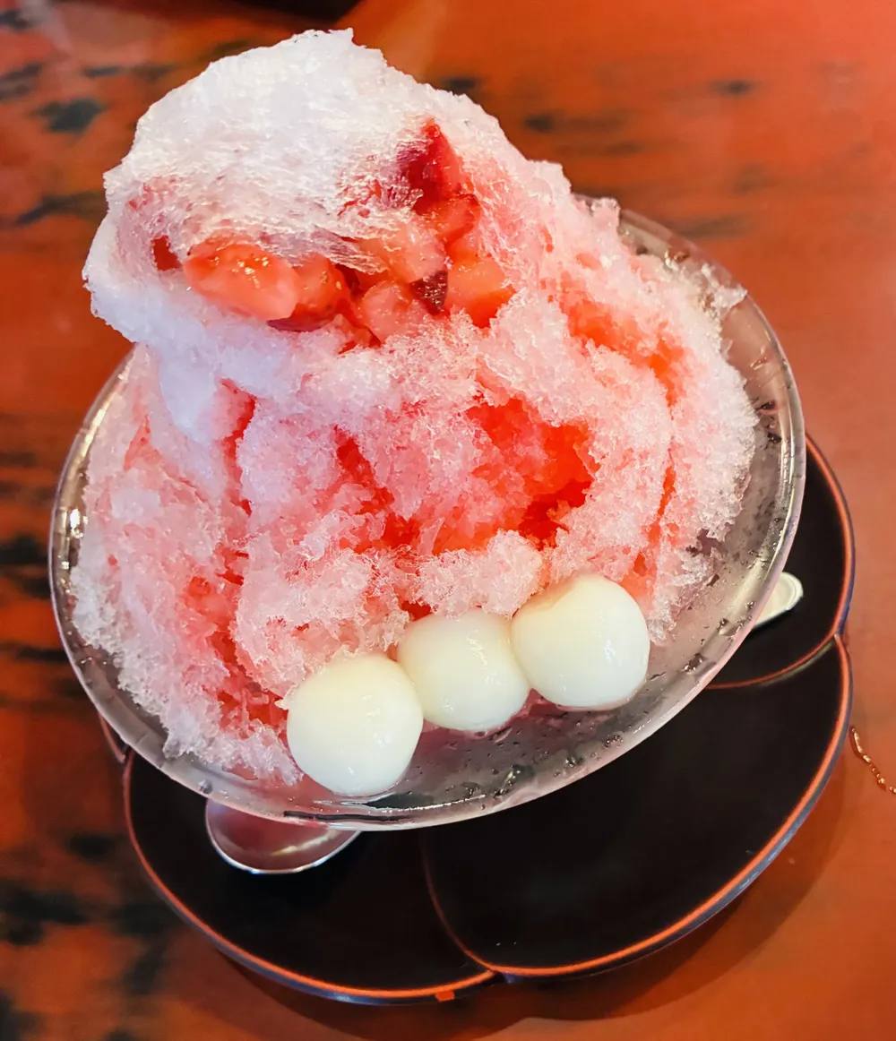 Kakigōri mit Erdbeersirup und Shiratama-Reisbällchen in einer Glasschale — das klassische japanische Sommerdessert aus fein gehobeltem Eis