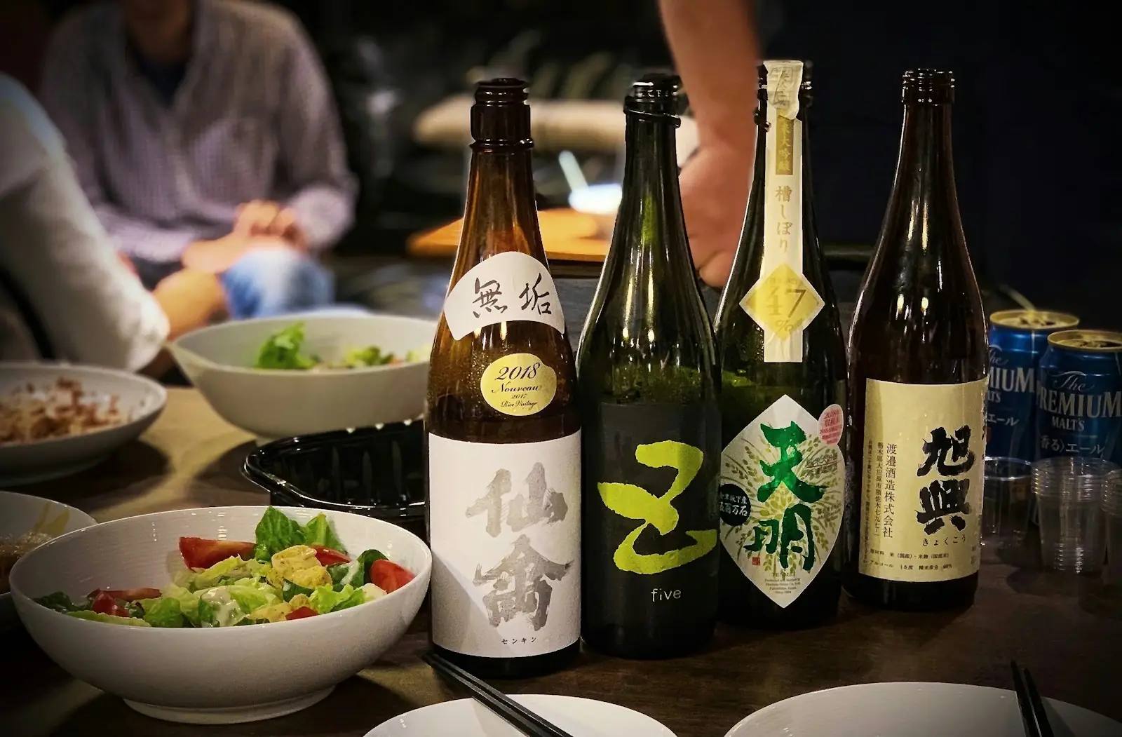 Flaschen japanischen Sakes neben Schälchen — die Brauereikultur etwa in Niigata gehört zu einer kulinarischen Reise durch Japan