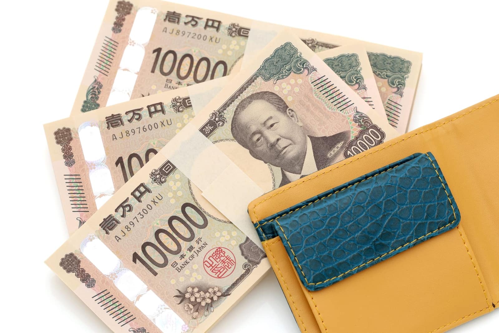 Japanische 10.000-Yen-Scheine und Geldbörse – der Wechselkurs bestimmt, wie viel Euro Sie für Ihr Yen-Budget benötigen