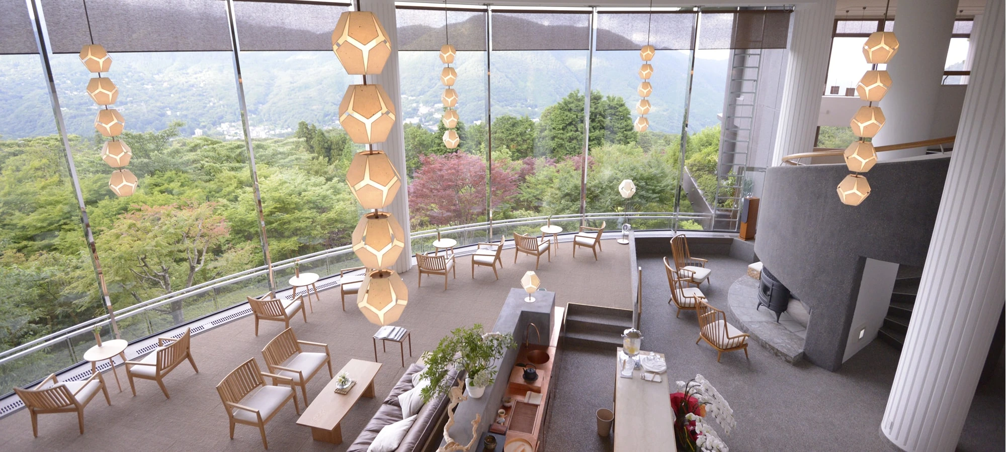 Lounge im Hakone Gora Byakudan mit hohen Fenstern, natürlichen Materialien und Blick auf die bewaldeten Berge